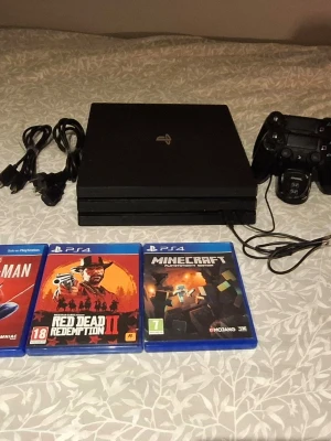 PlayStation 4 Pro med 2 handkontroller och spel - Sony PlayStation 4 Pro i gott skick, inklusive tre DualShock 4-kontroller, laddstation och strömkablar. Flera populära spel medföljer: Spider-Man, Spider-Man Miles Morales, Red Dead Redemption II och Minecraft. Perfekt för spelkvällar och underhållning.