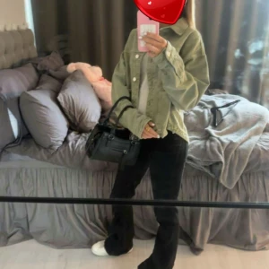 Grön jeansjacka med knappar - Säljer en snygg grön jeansjacka med klassisk krage och knäppning framtill. Jackan har en avslappnad passform och långa ärmar, perfekt att slänga över en hoodie eller t-shirt. Enkel och stilren design som passar till det mesta.