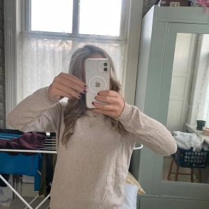 Beige stickad tröja från Jacqueline de Yong - Mysig beige stickad tröja från Jacqueline de Yong i storlek M. Tröjan har rund halsringning, ribbade muddar och lång ärm. Den sitter som en S