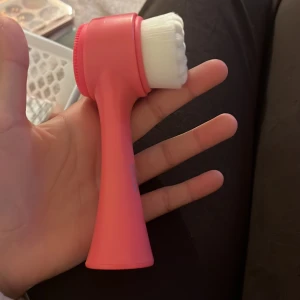 Cien Beauty  dubbelverkande -  från Cien Beauty i snyggt korallrosa plast. Ena sidan har täta vita borst för applicering och den andra sidan har en silikonborste med små piggar, perfekt för rengöring eller exfoliering. Ergonomiskt handtag för enkel användning.