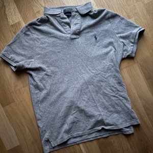Grå Polo Ralph Lauren piké - Säljer min gråa Ralph Lauren. Tröjan är en storlek M men passar även som S. Tröjan har bara används ett fåtal gånger och är i mycket bra skick. Har ni något att fråga är det bara att fråga på.