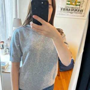 Grå stickad tröja med kort ärm - Mjuk och skön grå stickad tröja med korta ärmar. Tröjan har en avslappnad passform. Lite nopprig men går att ta bort. Skriv om du vill se fler bilder. Köpt på kids brandstore. Storlek 158/164