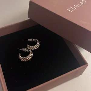 Silvriga örhängen  - Säljer ett par snygga silvriga örhängen. De är halvmåneformade med en cool bubblig struktur som ger dem en unik look. Perfekta för att lyfta vilken outfit som helst,