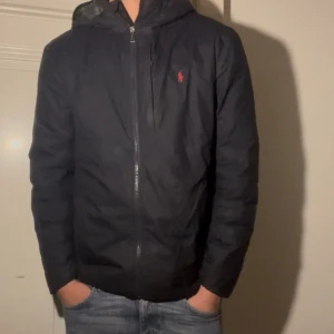 Mörkblå pufferjacka från Polo Ralph Lauren -  Marinblå Ralph Lauren jacka storlek M.  Jackan är  använd frekvent, bara att fråga om något undras pris kan diskuteras.👍🤝Jackan har en del defekter därav de låga priset, men vill upplysa om att ingen av dessa är särkilt synliga om du inte kollar nära och att tags medföljer.