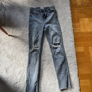 Gråa jeans med slitz från Zara -  Jeans  från Zara med hål på  båda knäna. Jeansen  är i stretchigt material denim).