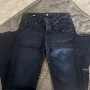 Svarta jeans från LTB W27 L32 - Snygga svarta jeans från LTB med klassisk femficksdesign och diskret tvättad look. Modellen har normal passform och raka ben, perfekt för dig som gillar stilrena och bekväma jeans. Tillverkade i stretchigt jeanstyg för extra komfort. Skriv för frågor eller funderingar. Ser helt oanvända ut.