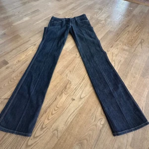 7 For All Mankind bootcut jeans blå - Snygga mörkblå jeans från 7 For All Mankind med klassisk bootcut och broderade bakfickor. Jeansen har dragkedja, fem fickor och är tillverkade i mjukt denimtyg med kontrastsömmar. Perfekta för dig som gillar en tidlös och cool look. Innerbenslängden är 86. Pris kan diskuteras 