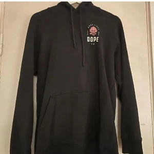 Svart hoodie med rosor från Dope - 2 dope med rosor, storlek 36 och M