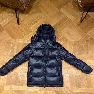 Glansig Ralph lauren jacka - Glansig Ralph lauren jacka i färgen svart| Skicket är super bra Inga defekter alls| HAR KVITTO FRÅN ZALANDO| Köptes för 6500 kr| Hör av er vid fler funderingar| 