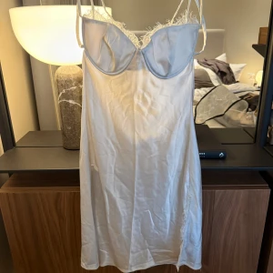 Vit satin miniklänning med spets - Vit miniklänning i satin från Carla Ginola x NA-KD. Perfekt om man vill vara ängel på halloween! Storlek 40 (M/L) Nypris 595kr.