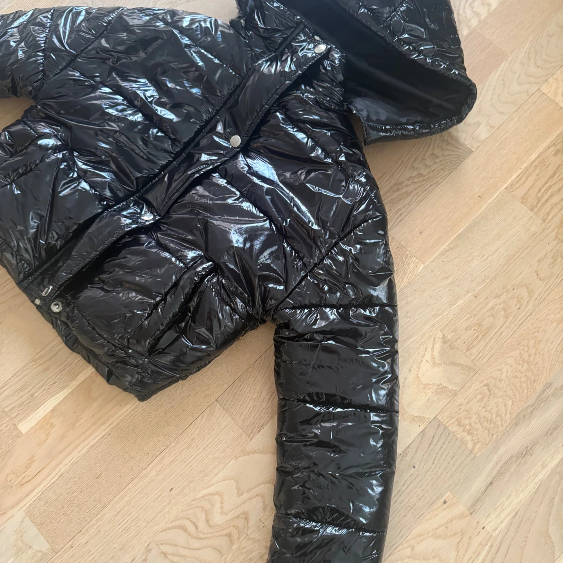 Svart glansig pufferjacka med huva - 1