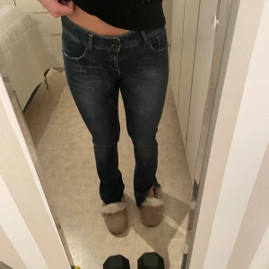 Mörkblå jeans från Vero Moda - Snygga mörkblå jeans från Vero Moda med låg midja och klassisk femficksdesign. Jeansen har raka ben med lätt bootcut och coola slitningar framtill. Materialet är stretchigt denim som sitter skönt och framhäver figuren.