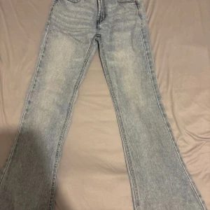 Ljusblå bootcut jeans från FB Sister - Säljer ett par ljusblå jeans från FB Sister i bootcut-modell. Jeansen har klassisk femficksdesign, hög midja och är tillverkade i denim med snygg tvättad look. Perfekta för dig som gillar retrovibbar och vill ha ett par jeans med lite vidare ben. Den är M men den skulle också passa S så bra 