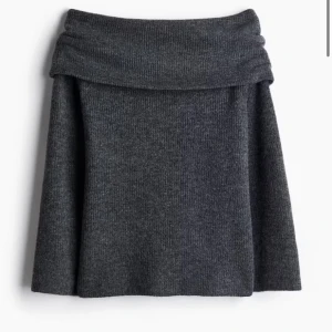 Mörkgrå stickad tröja med nedvikt kant - Mysig mörkgrå stickad off shoulder tröja med ribbad struktur och bred, nedvikt kant upptill. Tröjan har en lätt utställd form och är perfekt för dig som gillar en enkel men trendig look. Perfekt till höstig kväll. Jätte skön och mysig. Varmt tjockt material. Lite mer ljus i verklighet. Be om bild. Knappt använd