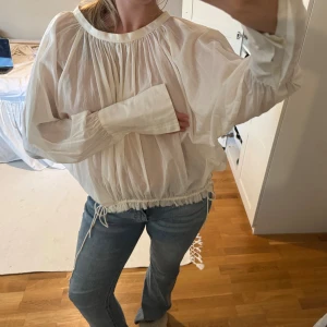 Vit blus med snörning och ballongärm - Luftig och transparent vit blus med ballongärmar och snörning i midjan. Står ingen storlek men skulle säga M/L🫰