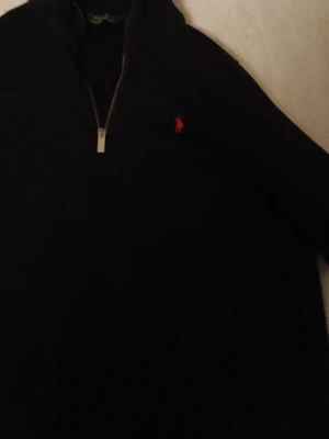 Svart half zip tröja Polo Ralph Lauren - Klassisk svart långärmad tröja från Polo Ralph Lauren med röd broderad logga på bröstet. Tröjan har en snygg half zip-dragkedja. Urtvättad därav pris men det syns inte på utsidan. Står M men skulle säga att den sitter som en S.