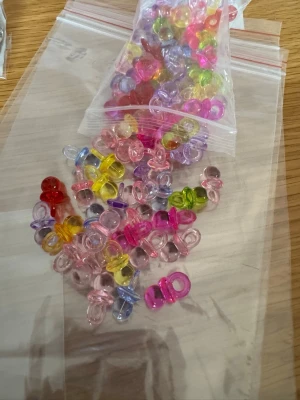 Färgglada nappar - Fick det till 98st . Kan även sälja i mindre portioner om man önskar . För smyckestillverkning eller andra roliga områden