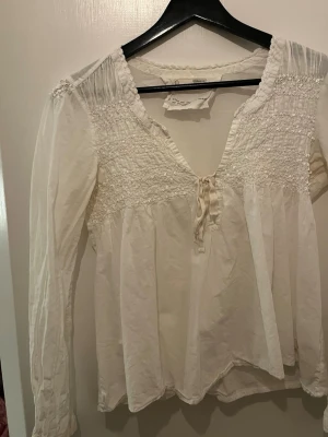 Vit blus - Blus med lite glittriga detaljer, står storlek 1 vilket är ungefär storlek S💕 Säljer även jeansen jag har på mig i en annan annons!!