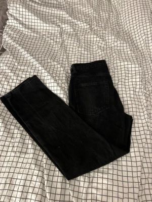 Svarta jeans från Lager 157 - Säljer ett par svarta jeans från Lager 157 i modellen New Classic. De har rak passform, klassiska fem fickor och normal midja. Jeansen är tillverkade i ett slitstarkt bomullsmaterial och har en enkel, stilren look som passar till det mesta.