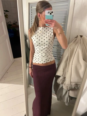 Vinröd stickad långkjol från VILA - Vinröd långkjol från VILA i stickat material. Kjolen har en rak och enkel design med mjuk resår i midjan. Perfekt för dig som gillar en stilren och bekväm look. Färgen är djup och passar till många olika outfits.