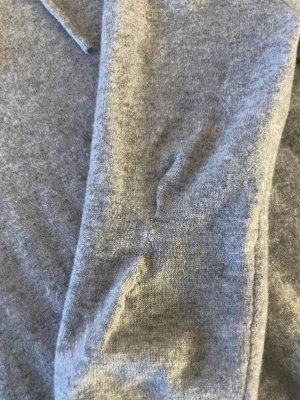 Grå cashmere hoodie från Sayless - Mjuk och lyxig grå hoodie från Sayless i 100% cashmere. Tröjan har huva med snörning och lätt långa ärmar. Perfekt för dig som vill ha en chill och stilren look med extra komfort.