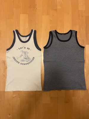 Två linnetoppar, vit och randig (barn) 4-6 år - Säljer två linnetoppar i mjuk bomull som passar barn med kroppslängd 110-116 cm eller 4-6 år. Båda säljes i samma paket.