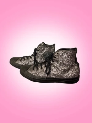 Glitter Converse  - Äkta höga glittriga converse i storlek 39,5. De är använda men ingen större defekt, ser hyfsat nya ut💕 Övrig information: -fraktar torsdagar, fredagar och lördagar -jag står inte för fraktens slarv -priset går alltid att diskuteras via dm -skriv privat för övriga frågor eller om du vill ha fler bilder, svarar snabbt