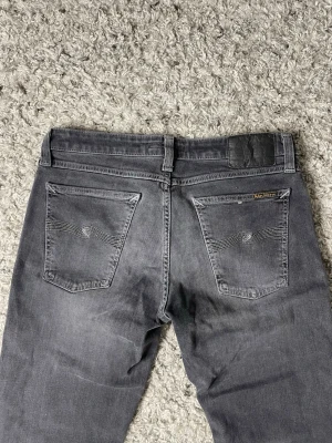 Grå jeans från Nudie Jeans - Säljer ett par gråa jeans från nudie jeans. Storleken på jeansen är W30 och L32. Passformen heter skinny lin. Nypris ligger på cirka 1699kr!