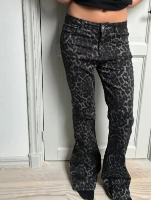 Svarta leopardmönstrade bootcut jeans - De populära Calzedonia jeansen med leopardmönster och bootcut passform. Byxorna har knapp och dragkedja framtill. Super fina, priset kan diskuteras😊