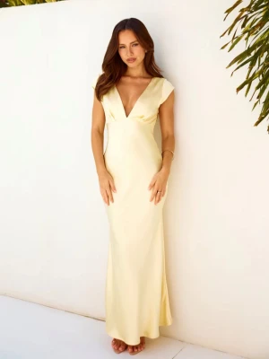 Ljusgul långklänning med öppen rygg - Supersnygg långklänning i ljusgul nyans med djup v-ringning och korta ärmar. Klänningen har en elegant öppen rygg med twistad detalj och är figurnära i modellen. Materialet ser ut att vara glansigt och faller fint längs kroppen, perfekt för sommarkvällar eller speciella tillfällen.
