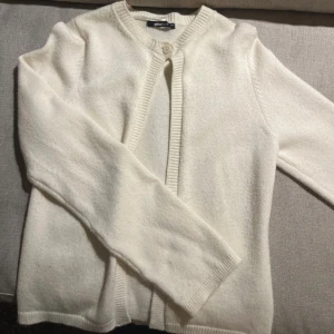 Vit kofta  - Vit kofta med en knapp, köpt från Gina Tricot. Koftan är nopprig  