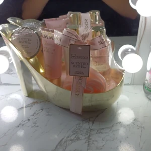 Guldig högklackad dekorationssko - Säljer en snygg dekorationssko i guld med hög klack och elegant form. Skon är tillverkad i ett glänsande syntetmaterial och har en stilren, modern look. Perfekt som inredningsdetalj eller presentförpackning. Skon är fylld med skönhetsprodukter men själva skon är i fokus här.