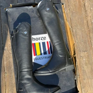 Svarta ridstövlar från Horze - Helt oanvända ridstövlar frän horze i storlek 35. 29 cm i vaden och 42 cm hög på utsidan. Säljs pågrund av att dom inte passa. Pris går att diskutera