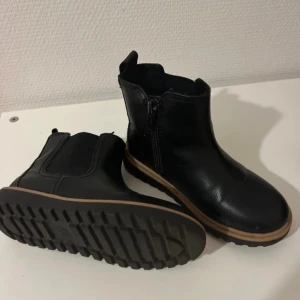 Svarta mellanlåga stövlar  - Svarta mellanlåga stövlar till barn i strl 28. Mycket bra skick och perfekt nu till hösten och vintern!