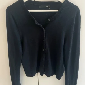  kofta från 157 - Svart/marinblå, klassisk kofta från 157 med rund hals och långa ärmar. Koftan har knappar framtill och är tillverkad i mjukt material som känns skönt mot huden. Perfekt att slänga över en t-shirt eller linne för en chill look. Tröjan är i storlek M men passar mig som har xs/s