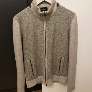 Hackett London zip up  - Riktigt snygg zip upp tröja från hackett london i 100% ull. Ett litet hål på armen som är åtgärdat (se bild 4), syns knappt. Så skick 9/10. Nypris runt 4000. Strl S men sitter mer som M. Passar dom som är mellan 175-185 cm beroende på hur man vill att den ska sitta. 