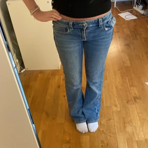 Blå bootcut jeans med broderade fickor - Snygga blå bootcut jeans med låg midja och broderade detaljer på bakfickorna. Ifrån Gina i strl 164