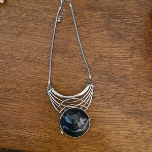Statement halsband med stor svart sten - Riktigt coolt stort halsband., lite plastig sten men snygg ändå. Köpt på secondhand, osäker på material tyvärr. Kolla in mina andra saker ja säljer!