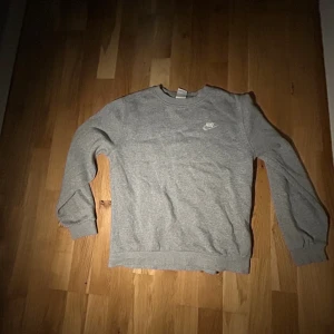 Grå Nike tröja - Säljer denna för att den inte passar mig längre och har knappast använt den så den är i väldigt bra skick! Storlek 158-170
