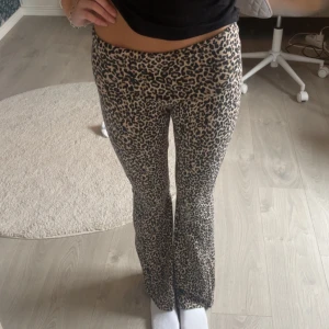 Leopardmönstrade yoga pants från Lindex - Säljer ett par snygga leopardmönstrade byxor från Lindex i storlek 170. Byxorna har låg midja och är i en beige och svart färgkombination. Modellen är bootcut med lite utsvängda ben och stretchigt material som sitter skönt. Perfekt för dig som gillar djurmönster!