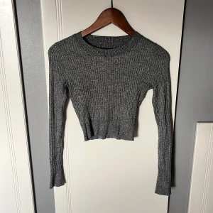 Grå ribbad croppad topp Even&Odd - Säljer en grå ribbad croppad topp från Even&Odd. Toppen har lång ärm, rund halsringning och har ett mjukt material. Står ej storlek på toppen men den är storlek xs/s. 