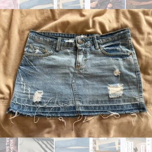 Jeanskjol - Assnygg blå jeanskjol med slitningar. Bara att skriva vid frågor❤️❤️ pris går att justera vi snabb affär. Svårt att få färgen på bild men mer som de sista bilderna men inte lika mycket struktur. 