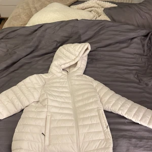 Vit pufferjacka med huva från 157 - Säljer nu min jacka den lager 157 då jag inte ha rnågon användning för den. Den har blivit använd 1 gång. Den är i krämvit färg och väldigt skön att ha på sig. Den är i stl S. Pris kan diskuteras vid snabb affär.
