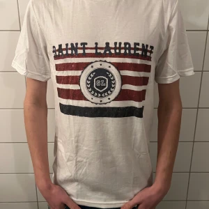 Saint Laurent t shirt - Riktigt fet och eftertraktad t shirt med saint laurent loggan. Storlek S, skick 10/10!! Modellen på bilden är 183cm. Saknar tag då är lite osäker på äktheten så därför är priset just nu på 699kr! Nypris runt 4000! Tveka inte med att ställa frågor!