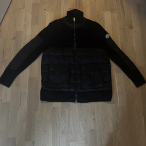 Svart Moncler cardigan  - Svart Moncler-jacka som är helt ny och oanvänd, den har bara legat i min garderob och bur har jag valt att sälja den. Vid funderingar så är det bara och skriva. Storlek M.