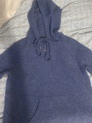 stickad hoodie - En klassisk mörkblå stickad hoodie med rund halsringning och ribbade muddar. Jätte mysig speciellt nu på vintern