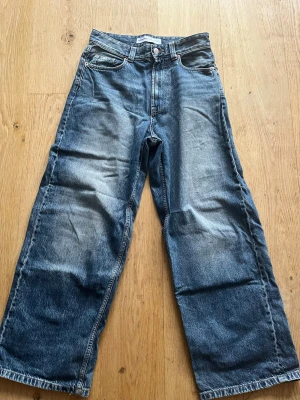 Blåa baggy jeans från Bershka - Säljer ett par blåa jeans från Bershka med baggy passform. Jeansen har en snygg tvätt med slitningar. Perfekta för en avslappnad och trendig look. Storlek W30 L34. Skriv om du har några frågor! Priset går att diskutera!