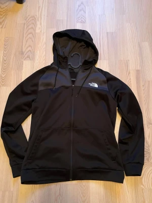 Svart zip hoodie från The North Face - Svart zip hoodie med från The North Face. Tröjan är svart med gråa detaljer. Väldigt bra skick på denna tröja. Skicka ett meddelande vid frågor! 