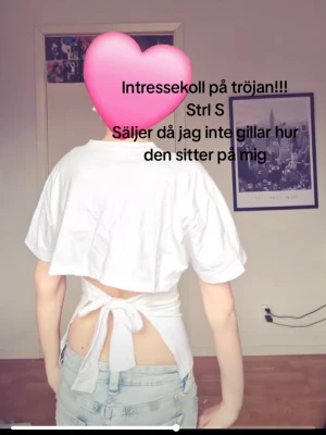 Vit croppad topp med knyt i ryggen - Säljer en omsydd vit topp med korta ärmar och snygg knytning i ryggen. Toppen har en öppen rygg och är perfekt för dig som vill ha en unik och trendig look. Passar till jeans eller kjol för en cool stil. Från Ralph Lauren. Strl S!