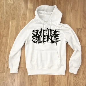 Rare Suicide Silence  pull the trigger hoodie (2007) - Texten på tröjan är en referens till låten No Pity For A Coward från deras ikoniska album The Cleansing (2007). Albumet räknas som ett av de mest inflytelserika släppen inom deathcore och heavy metal och spelade en stor roll i att forma scenen under MySpace-eran. Suicide Silence blev kända för sitt extremt aggressiva sound med nedstämda gitarrer, intensiva trummor och råa, kraftfulla vocals. The Cleansing satte ribban för hur brutal och kompromisslös genren kunde vara. 